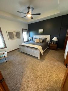 um quarto com uma cama e uma ventoinha de tecto em Friendly Falls Staycation em Sioux Falls