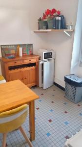eine kleine Küche mit einem Tisch und einem kleinen Kühlschrank in der Unterkunft gite de la butte aux oiseaux in Saint-Alban-sur-Limagnole
