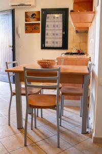 ヴァッレドーリアにあるValledoria 2 Apartmentsのキッチン(木製テーブル、椅子、カウンター付)