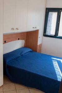 ヴァッレドーリアにあるValledoria 2 Apartmentsのベッドルーム(青いベッド1台、窓付)
