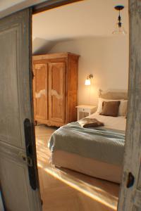 - une chambre avec un lit et une armoire en bois dans l'établissement Le Domaine des Cyclamens, à Verneuil-sur-Indre