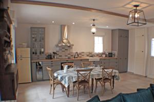 - une cuisine et une salle à manger avec une table et des chaises dans l'établissement Le Domaine des Cyclamens, à Verneuil-sur-Indre