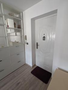 a white door in a room with white shelves at Tin Apartment in Vatra Dornei