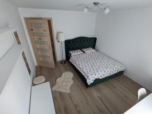 a small bedroom with a bed and a dresser at Tin Apartment in Vatra Dornei