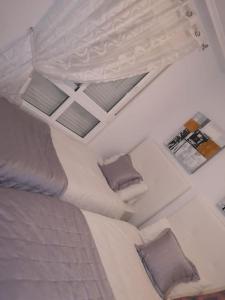 een slaapkamer met een groot bed met twee kussens bij Casa JC in Orihuela