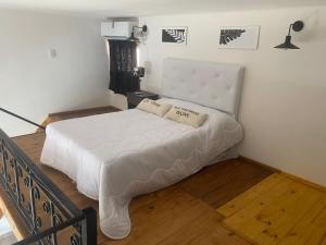 una camera da letto con un letto bianco con due cuscini sopra di AQUI ES 2 !!! a Banfield