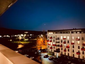 a building with red squares on the side of it at night at A&Y APARTAMENT in Floreşti