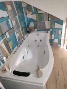 y baño con bañera blanca y azulejos de colores. en Figli Di Agata, en Catania
