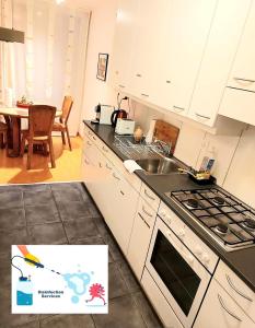 uma cozinha com armários brancos e um forno com placa de fogão em Large Apartment Bern City Centre em Berna