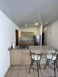 uma cozinha com duas cadeiras e uma bancada em CORONADO VILLA VICTORIA em San Carlos