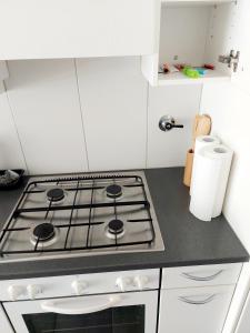 um forno com placa de fogão numa cozinha com armários brancos em Large Apartment Bern City Centre em Berna