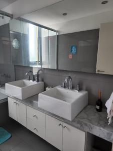 a bathroom with two sinks and a large mirror at Apartamento Av kennedy y Cerviño a metros embajada EEUU in Buenos Aires