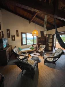 a living room with chairs and a couch and a table at Casa Marrom in Bombinhas