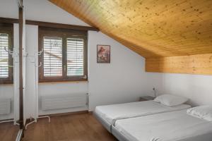 ベットマーアルプにあるAlpenglück 51の木製の天井が特徴のベッドルーム1室(ベッド2台付)