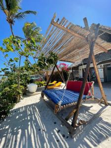 - un hamac sur une plage avec un palmier dans l'établissement Bitcoin Beach Hotel Zanzibar, à Pingwe