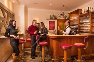 a group of people standing around a bar at Hotel Alpenblick in Bad Gastein