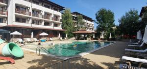 a swimming pool in front of a hotel with people in it at MM Complex in Primorsko
