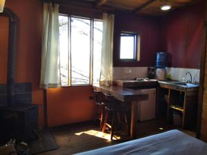 cocina con mesa, fregadero y ventana en Terrazas de Laguna Verde, en Laguna Verde