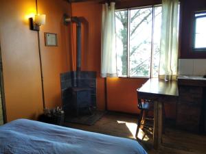 a bedroom with a wood stove and a bed and a desk at Terrazas de Laguna Verde in Laguna Verde