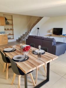 a wooden table in a living room with a couch at Gîte Douceur de Provence in Maubec