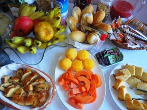 a table with plates of fruits and vegetables on it at Pousada Bahia Morena in Salvador