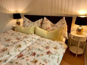 a bed with a floral comforter and pillows at Charming Apartment with Mountain View in Altmünster