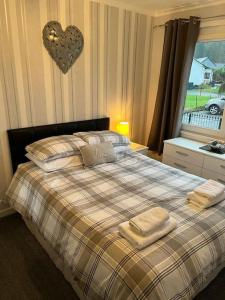 a bedroom with a bed with two towels on it at Stunning views in Lochgoilhead
