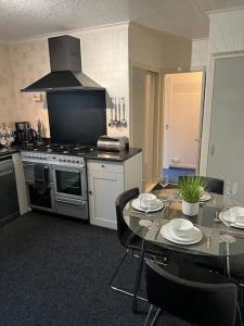 a kitchen with a table with chairs and a stove at Stunning views in Lochgoilhead