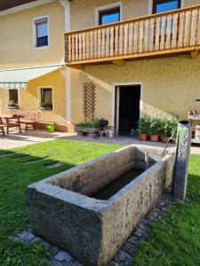 un gran plantador de piedra frente a una casa en Ferdlhof Ferienwohnung, en Ulrichsberg