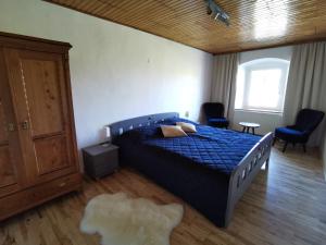 a bedroom with a bed with a blue comforter at Ferdlhof Ferienwohnung in Ulrichsberg