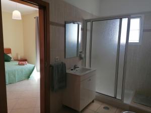 a bathroom with a sink and a shower and a bed at Despertar do Sol in Santa Cruz