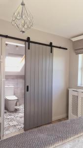 a sliding door in a bathroom with a toilet at Old Farmhouse Annex in Clones