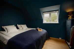 a blue bedroom with a bed and a window at Nyrenovert leiliget 1 min unna solsiden in Trondheim