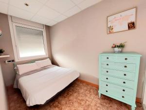 ein Schlafzimmer mit einem Bett, einer Kommode und einem Fenster in der Unterkunft Apartamento Sant Roc in Vandellòs i l’Hospitalet de l’Infant