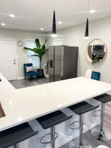 a kitchen with a white counter and stools at Cozy Short & Suite 4-Bedroom Stay- Minutes to City in Quincy