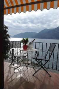 マローネにあるNest on The Lakeのテーブルと椅子、水辺の景色を望むバルコニー