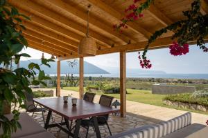 drewniana pergola ze stołem i krzesłami na patio w obiekcie Knots apartments w miejscowości Ágios Nikólaos