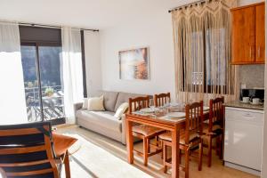 sala de estar con mesa y sofá en Apartament Mufló Apartamento encantador con vistas espectaculares a la X de Grandvalira, en El Tarter