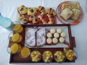 a tray of bread and pastries and glasses of orange juice at 7 esencias in Villa Yacanto