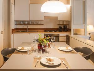 a kitchen with a table with plates and wine glasses at Nest on The Lake in Marone