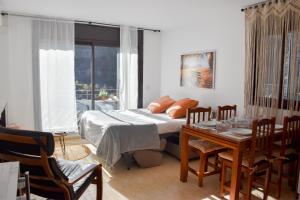 a bedroom with a bed and a table with chairs at Apartament Mufló Apartamento encantador con vistas espectaculares a la X de Grandvalira in El Tarter