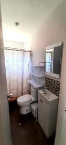 a bathroom with a toilet and a sink and a mirror at Casa Naranja in Máncora