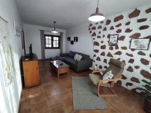 ein Wohnzimmer mit einem Sofa und einer Steinmauer in der Unterkunft Apartamento Casa Belen in Conil