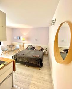a bedroom with a bed and a round mirror at SKALNY apartamenty, pokoje in Ogrodzieniec