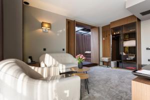 a hotel room with a bed and a couch and a table at Abrazo Sofia Hotel by HMG in Sofia