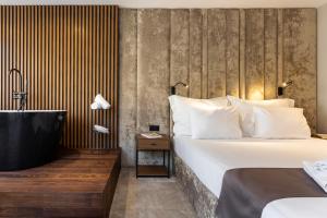 a hotel room with a bed and a bath tub at Abrazo Sofia Hotel by HMG in Sofia