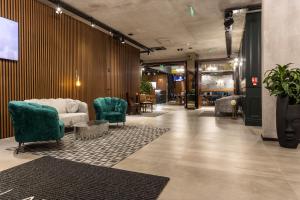 a lobby with a couch and chairs and tables at Abrazo Sofia Hotel by HMG in Sofia