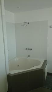 y baño con bañera y lavamanos. en Nuevo Paracas Apartment, en Paracas