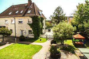 Haus Strandgang, Whg 11 في كيلينهوسن: منزل به حديقة وممشى