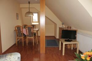 een woonkamer met een tv en een tafel met stoelen bij Haus Strandgang, Whg 12 in Kellenhusen